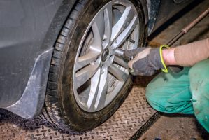 Seasonal tyre replacement. Auto mechanic changing car wheel.